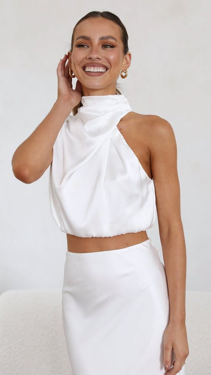 crop top αμάνικο με όψη σατέν και ντραπέ ντεκολτέ αποπνέει μια αύρα κομψότητας και στυλ που ξεχωρίζει. Η υφή του σατέν προσφέρει μια λαμπερή υφή, δημιουργώντας ένα απαλό και ιδιαίτερα ελκυστικό φινίρισμα. Το crop top σχέδιο παρέχει μια μοντέρνα προσέγγιση. Το αμάνικο στυλ προσθέτει άνεση και φινέτσα, καθώς επιτρέπει την ελευθερία κίνησης, ενώ το ντραπέ ντεκολτέ προσθέτει μια διακριτική δόση θηλυκότητας. Η λεπτομέρεια του ντραπέ προσδίδει όγκο και διασκεδαστική διάσταση στο crop top, δημιουργώντας ένα ιδι