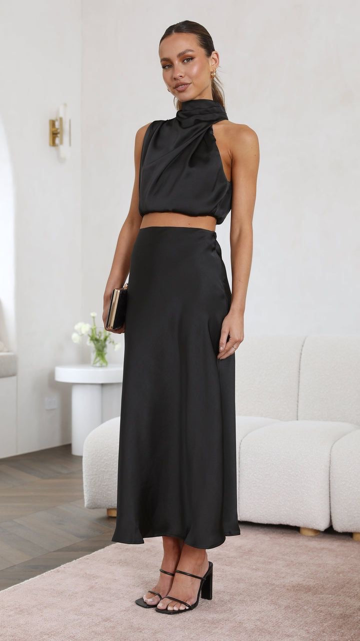 Το crop top αμάνικο με όψη σατέν και ντραπέ ντεκολτέ αποπνέει μια αύρα κομψότητας και στυλ που ξεχωρίζει. Η υφή του σατέν προσφέρει μια λαμπερή υφή, δημιουργώντας ένα απαλό και ιδιαίτερα ελκυστικό φινίρισμα. Το crop top σχέδιο παρέχει μια μοντέρνα προσέγγιση. Το αμάνικο στυλ προσθέτει άνεση και φινέτσα, καθώς επιτρέπει την ελευθερία κίνησης, ενώ το ντραπέ ντεκολτέ προσθέτει μια διακριτική δόση θηλυκότητας. Η λεπτομέρεια του ντραπέ προσδίδει όγκο και διασκεδαστική διάσταση στο crop top, δημιουργώντας ένα ιδι
