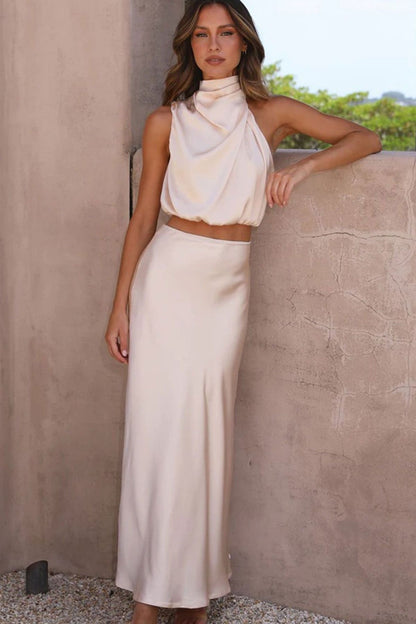 crop top αμάνικο με όψη σατέν και ντραπέ ντεκολτέ αποπνέει μια αύρα κομψότητας και στυλ που ξεχωρίζει. Η υφή του σατέν προσφέρει μια λαμπερή υφή, δημιουργώντας ένα απαλό και ιδιαίτερα ελκυστικό φινίρισμα. Το crop top σχέδιο παρέχει μια μοντέρνα προσέγγιση. Το αμάνικο στυλ προσθέτει άνεση και φινέτσα, καθώς επιτρέπει την ελευθερία κίνησης, ενώ το ντραπέ ντεκολτέ προσθέτει μια διακριτική δόση θηλυκότητας. Η λεπτομέρεια του ντραπέ προσδίδει όγκο και διασκεδαστική διάσταση στο crop top, δημιουργώντας ένα ιδι