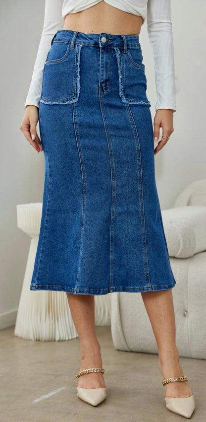 Ψηλόμεση denim midi φούστα με κάθετες ραφές και λεπτομέρεια τσέπες με ξέφτια εξωτερικά.Εφαρμοστή στο πανω μέρος και ανοίγει κάτω σε στυλ mermaid.

 Κλείνει με κουμπί και φερμουάρ και διαθέτει τέσσερις τσέπες.Διαθέτει μικρή ελαστικότητα, κανονική εφαρμογή true to size. 