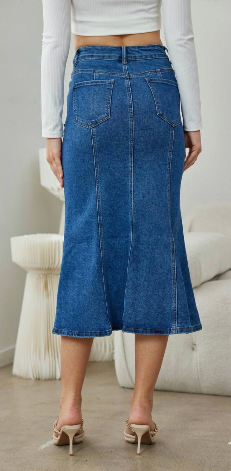 Ψηλόμεση denim midi φούστα με κάθετες ραφές και λεπτομέρεια τσέπες με ξέφτια εξωτερικά.Εφαρμοστή στο πανω μέρος και ανοίγει κάτω σε στυλ mermaid.

 Κλείνει με κουμπί και φερμουάρ και διαθέτει τέσσερις τσέπες.Διαθέτει μικρή ελαστικότητα, κανονική εφαρμογή true to size. 