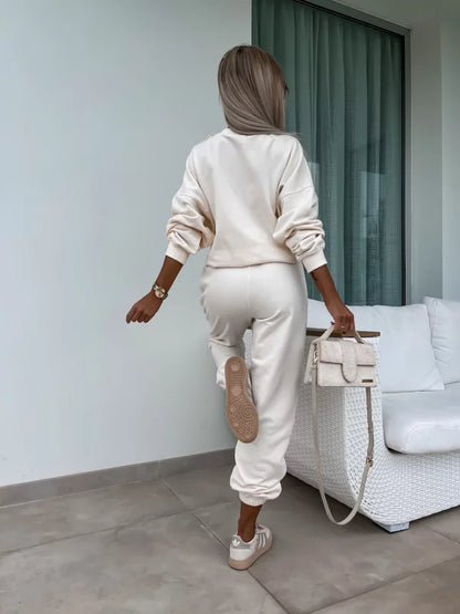 Άνετο ελαστικό σετ φόρμας με φούτερ oversized μακρυμάνικο με στρογγυλή λαιμόκοψη και παντελόνι φόρμας με λάστιχο στη μέση και τα πατζάκια.

