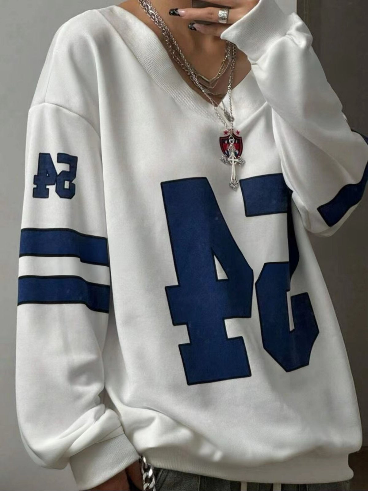 Αθλητικό φούτερ oversized με V λαιμό, φιλια επένδυση και τυπωμένους  αριθμούς και γραμμές σε αντίθεση χρωμάτων.Διαθέσιμο σε λευκό μαύρο και γκρι χρώμα.